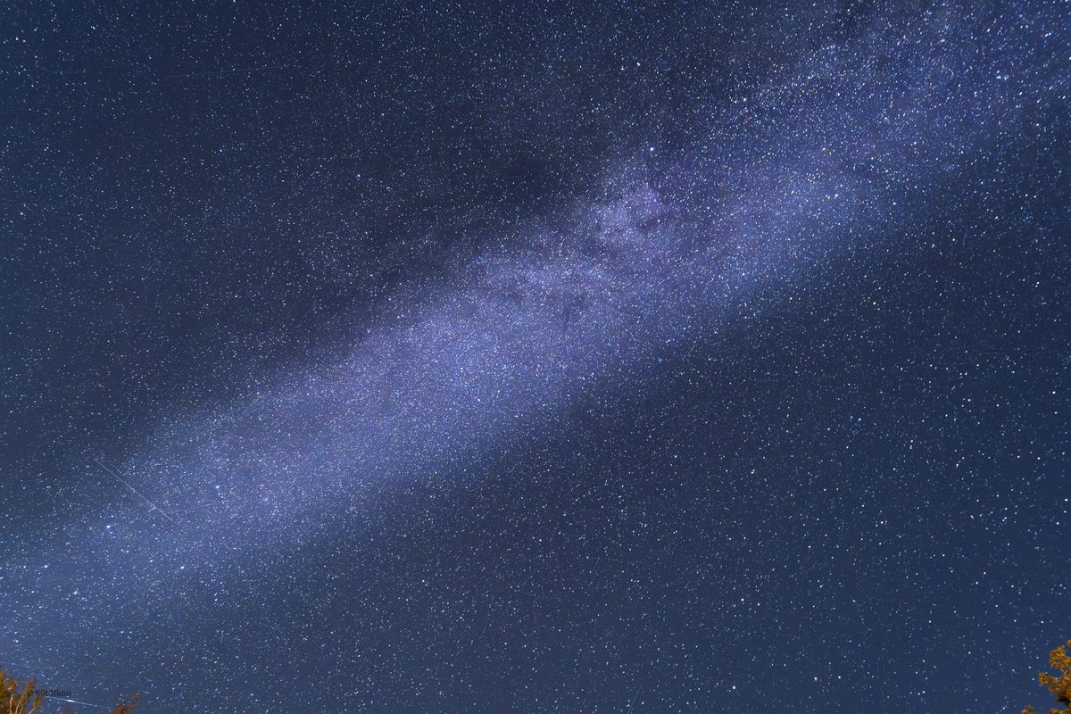 The Milky Way band running corner to corner over a deep blue sky